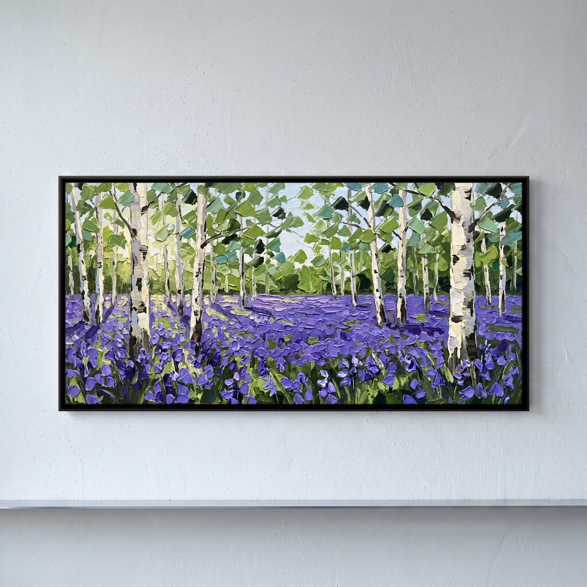 Birches Over a Bluebell Field - framed canvas art hung on a wall