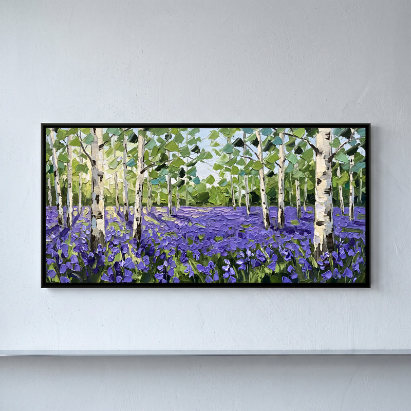 Birches Over a Bluebell Field - framed canvas art hung on a wall