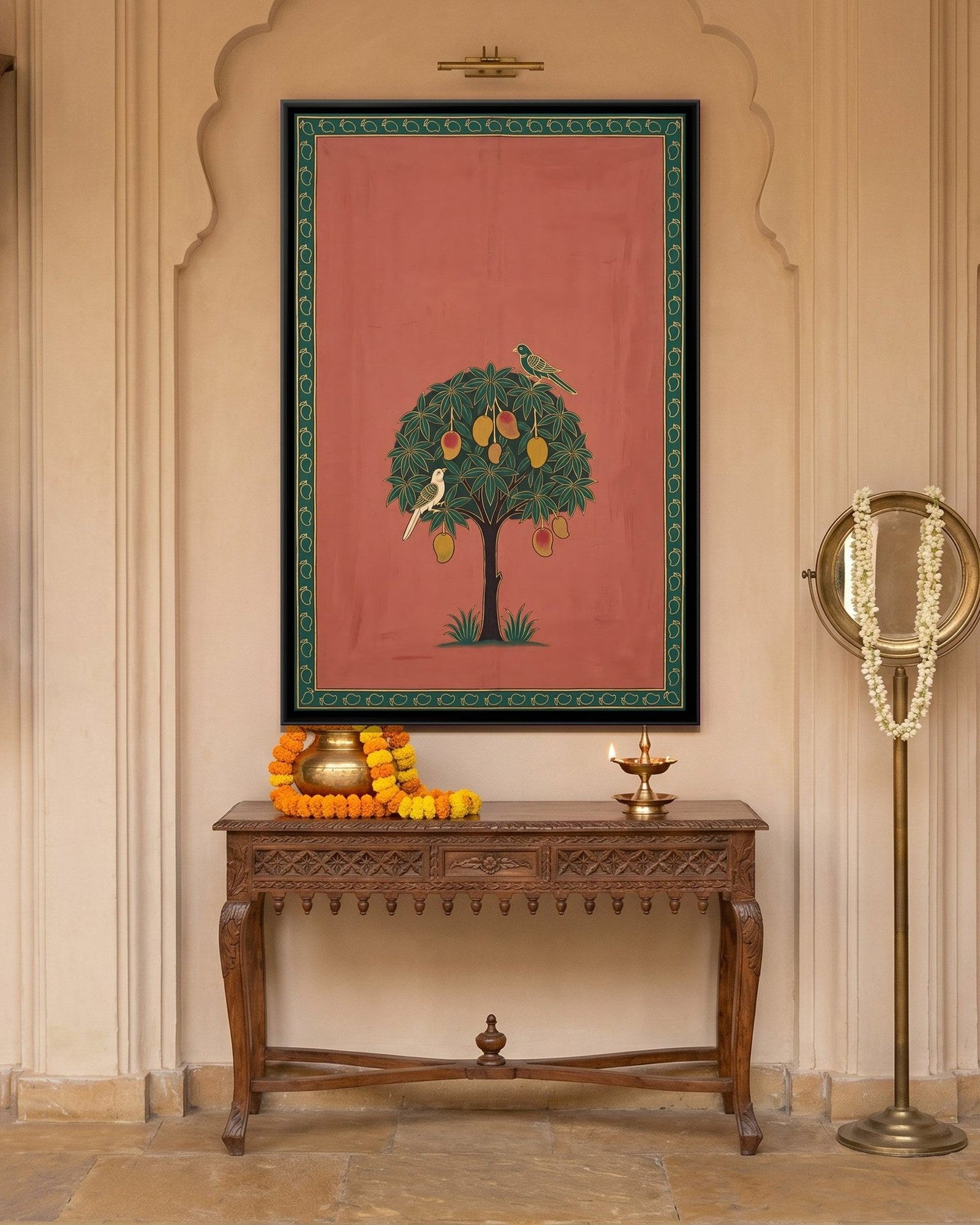 A Mango Tree with Parrots pichwai canvas in a carved arched alcove above a wooden console
